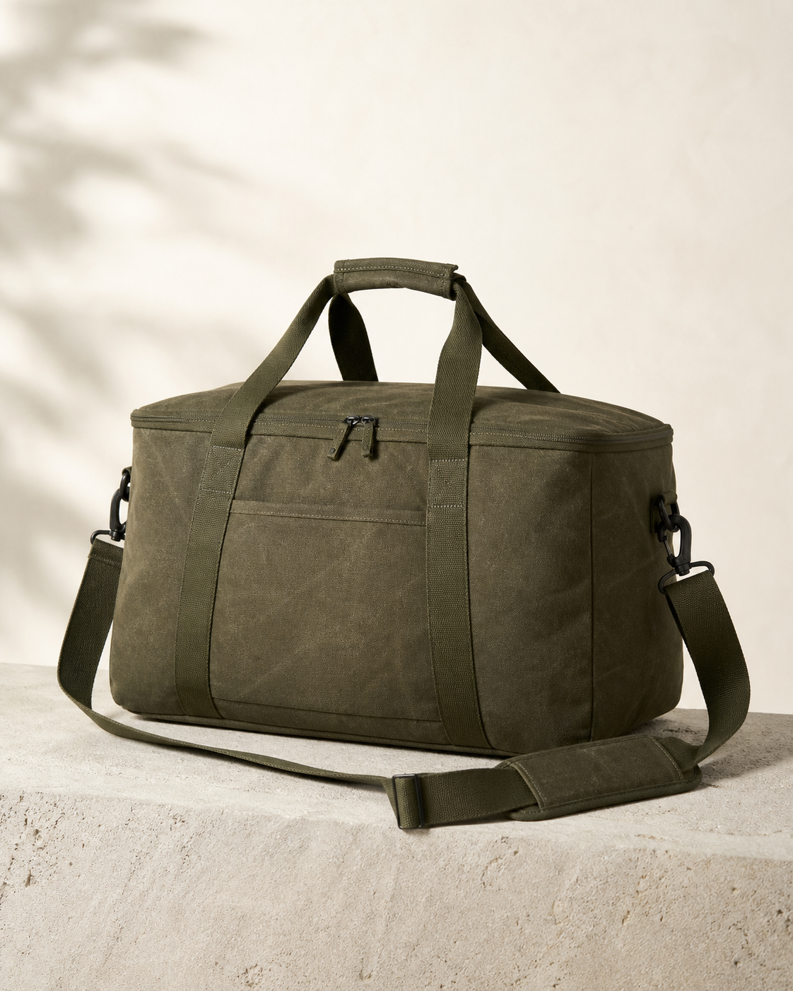 Tomei Weekender 28 in Olive Wax, a 28 litre two nights, one bag, no negotiation bag, photographed on a stone plinth